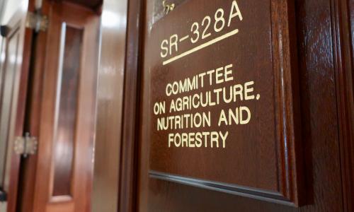 photo of a wall plaque made of dark wood with gold lettering that reads "SR-328A Committee on Agriculture, Nutrition and Forestry"