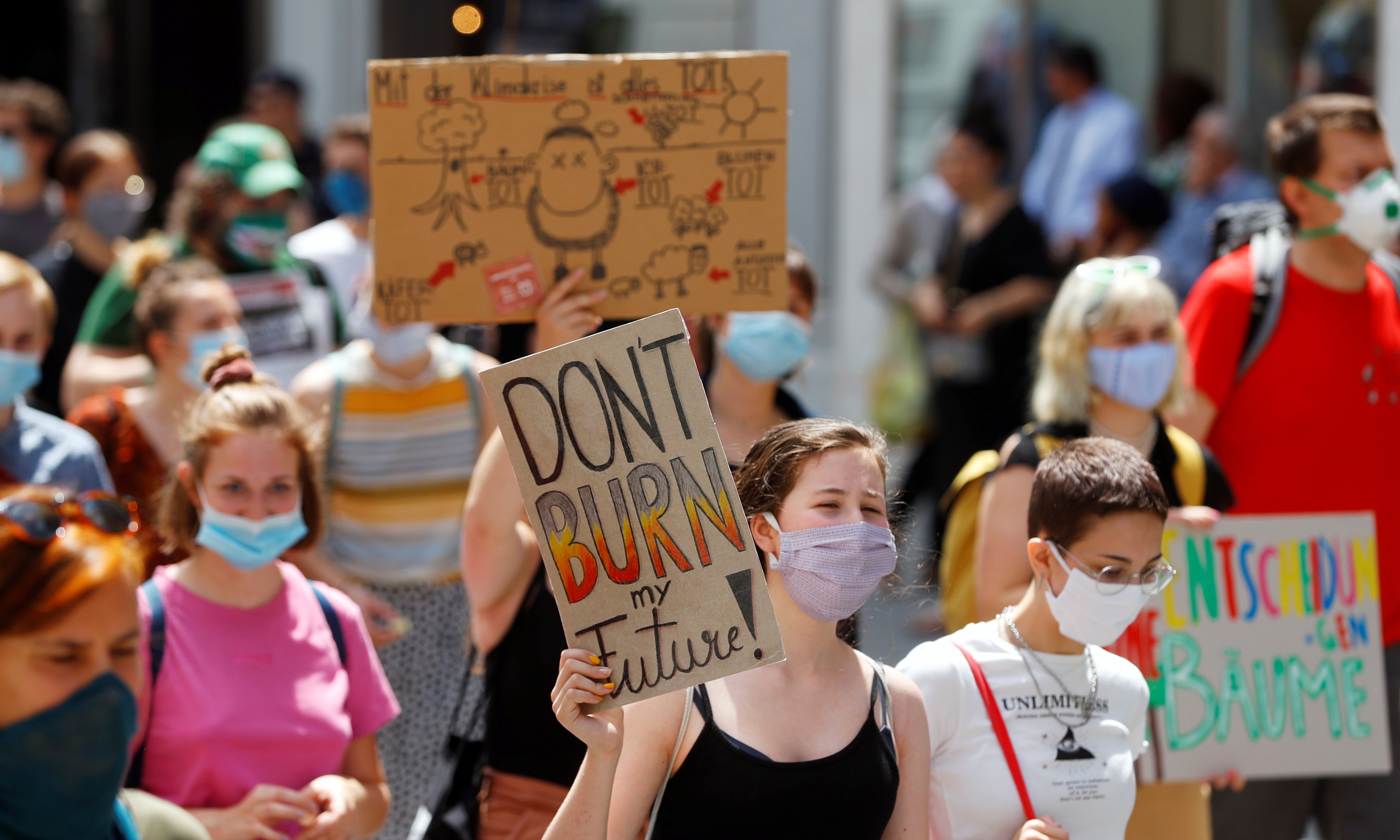 Climate change protester carries a sign that says 'Don't burn my future'