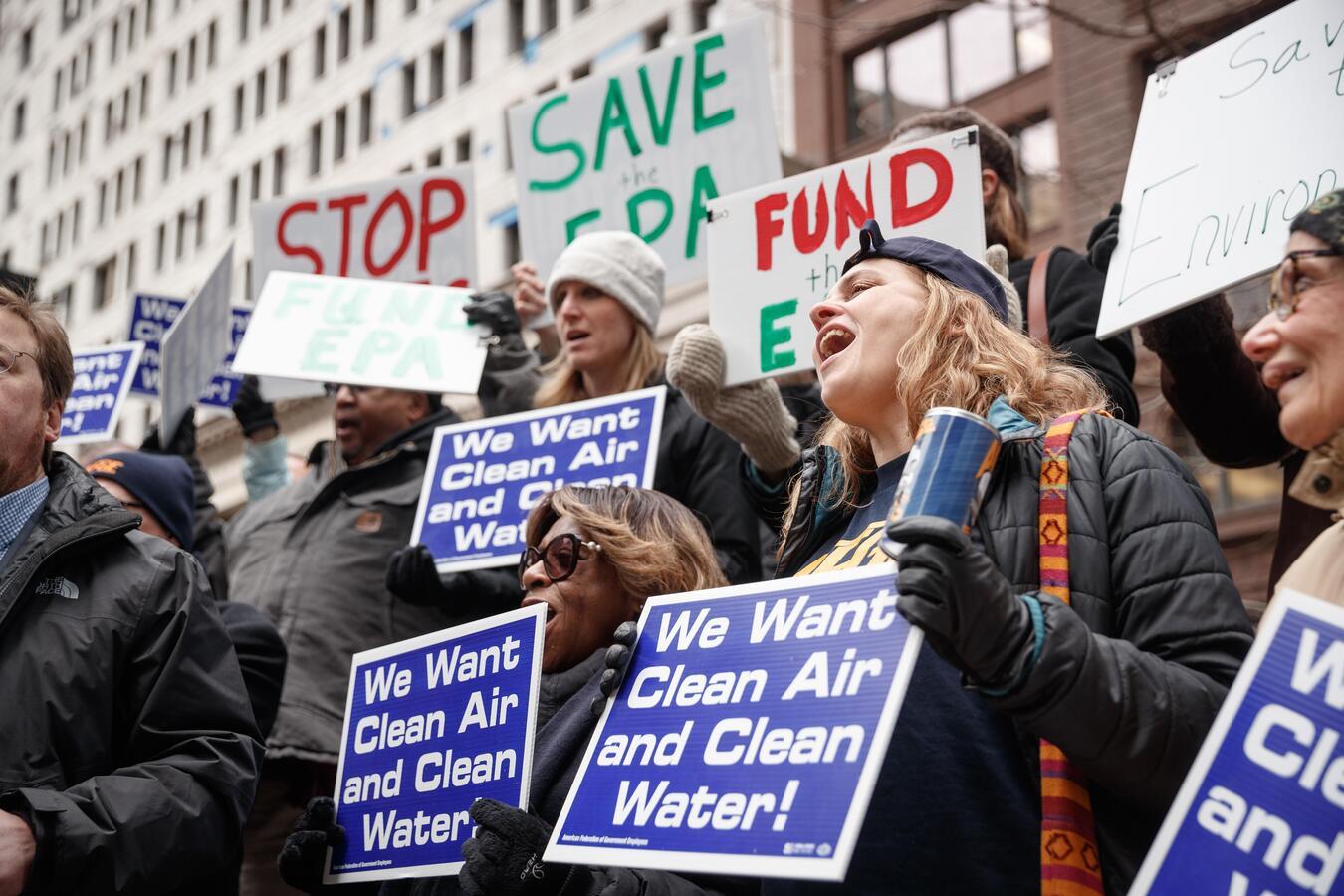 A group of people hold signs that read "We Want Clean Air and Clean Water!"