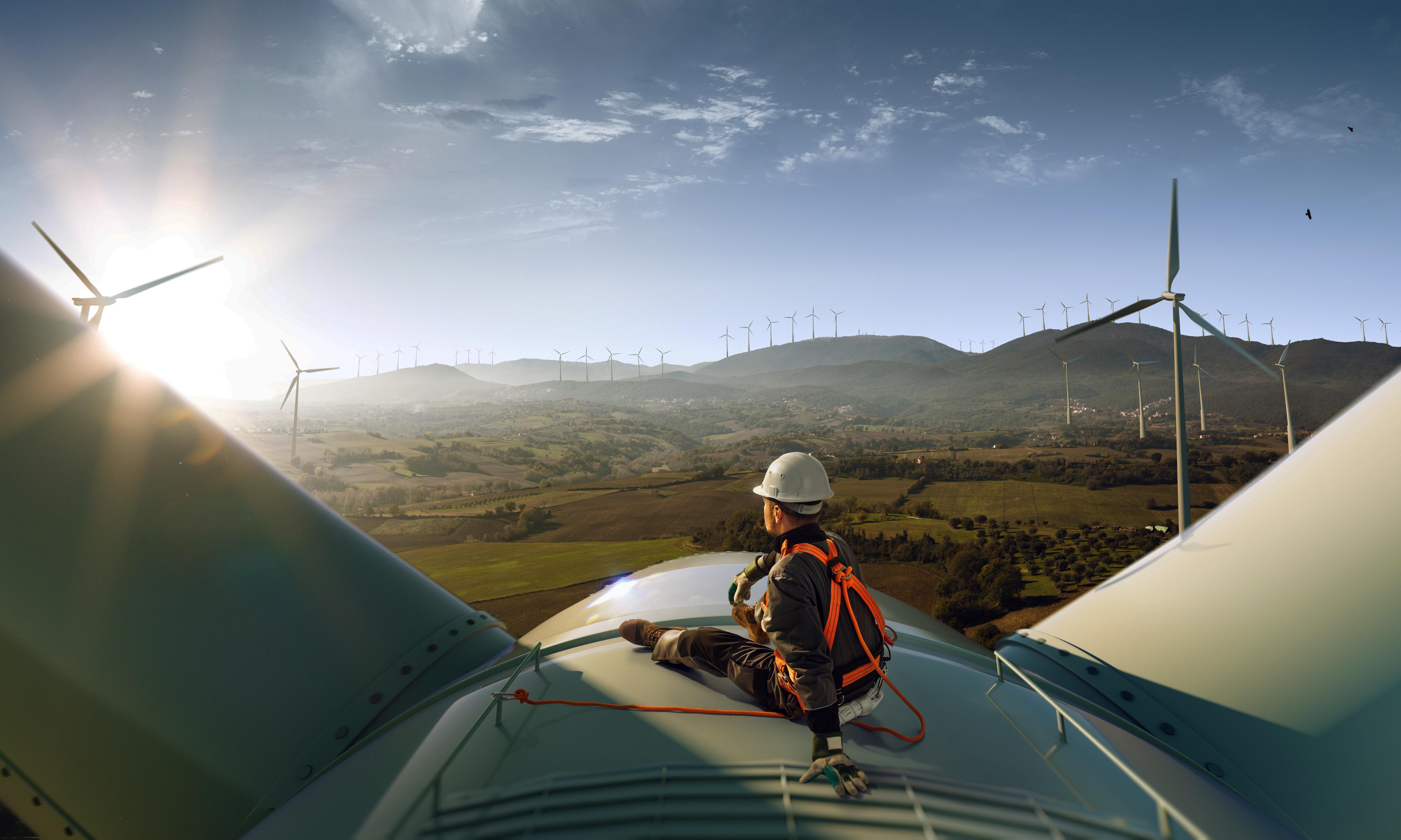 A worker on top of a wind turbine