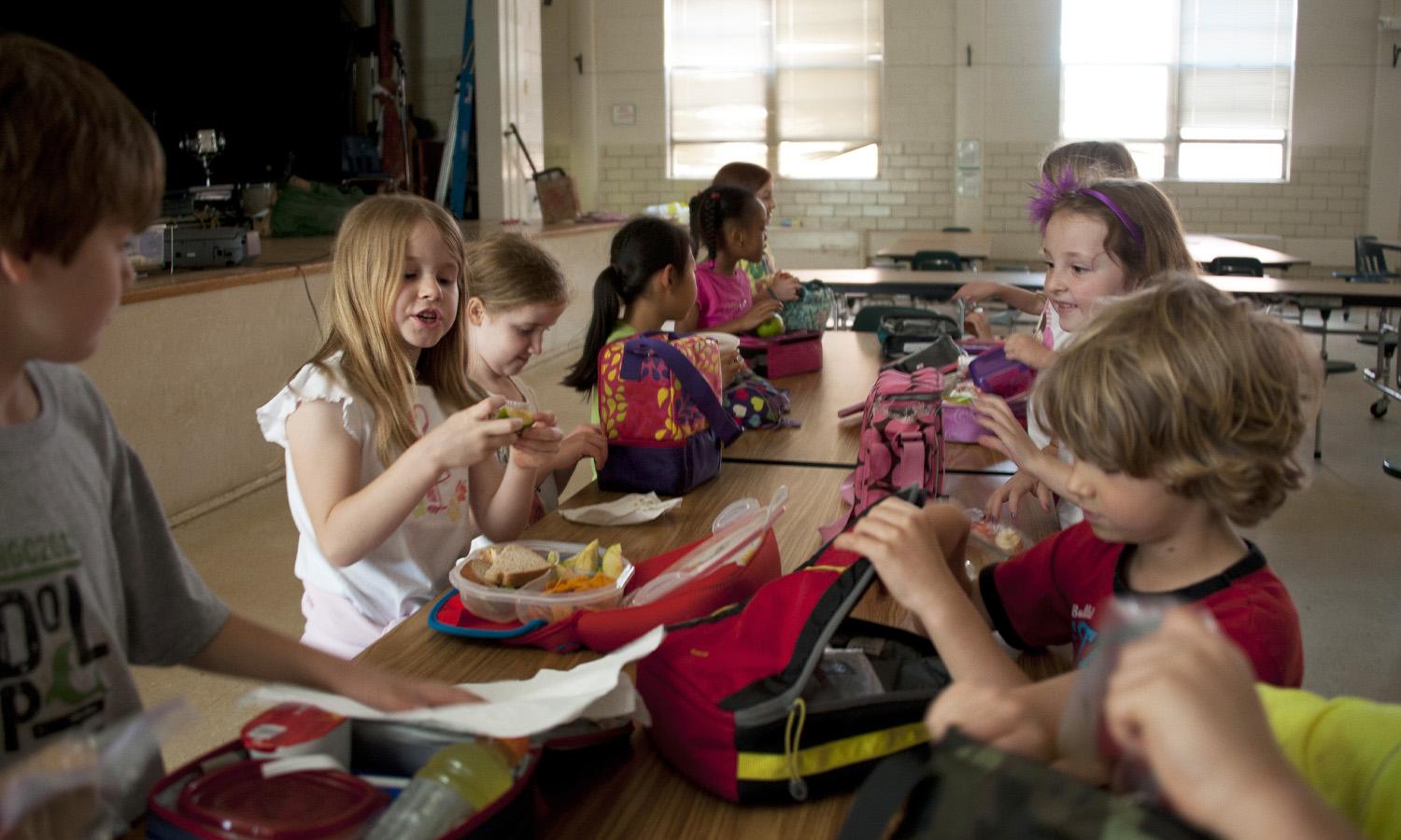Children eating at a school lunch table.