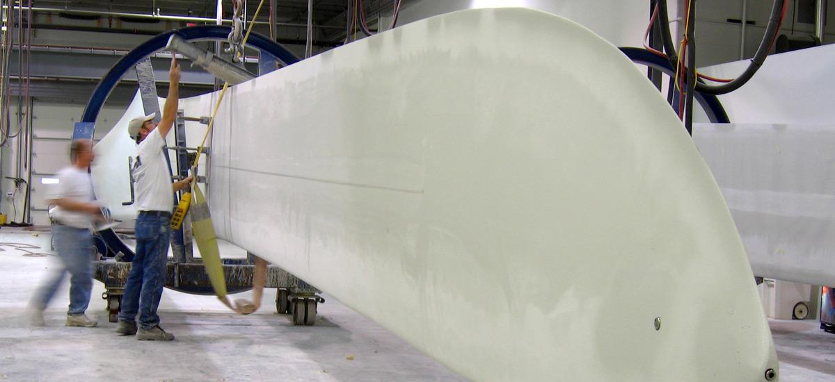 Two people working on a wind turbine blade.