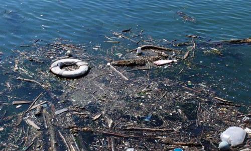 Polluted water with trash floating in it