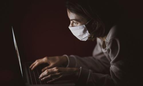 Masked woman on laptop