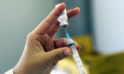 A syringe being filled with a vaccine.